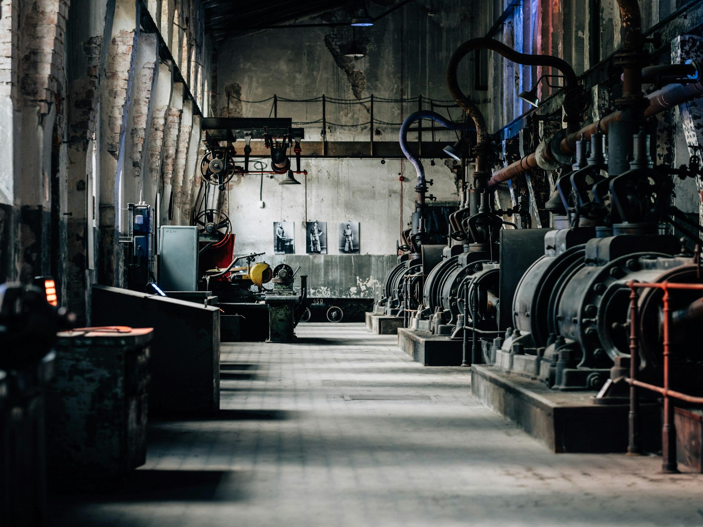 Long industrial hall lined with heavy machinery under natural light