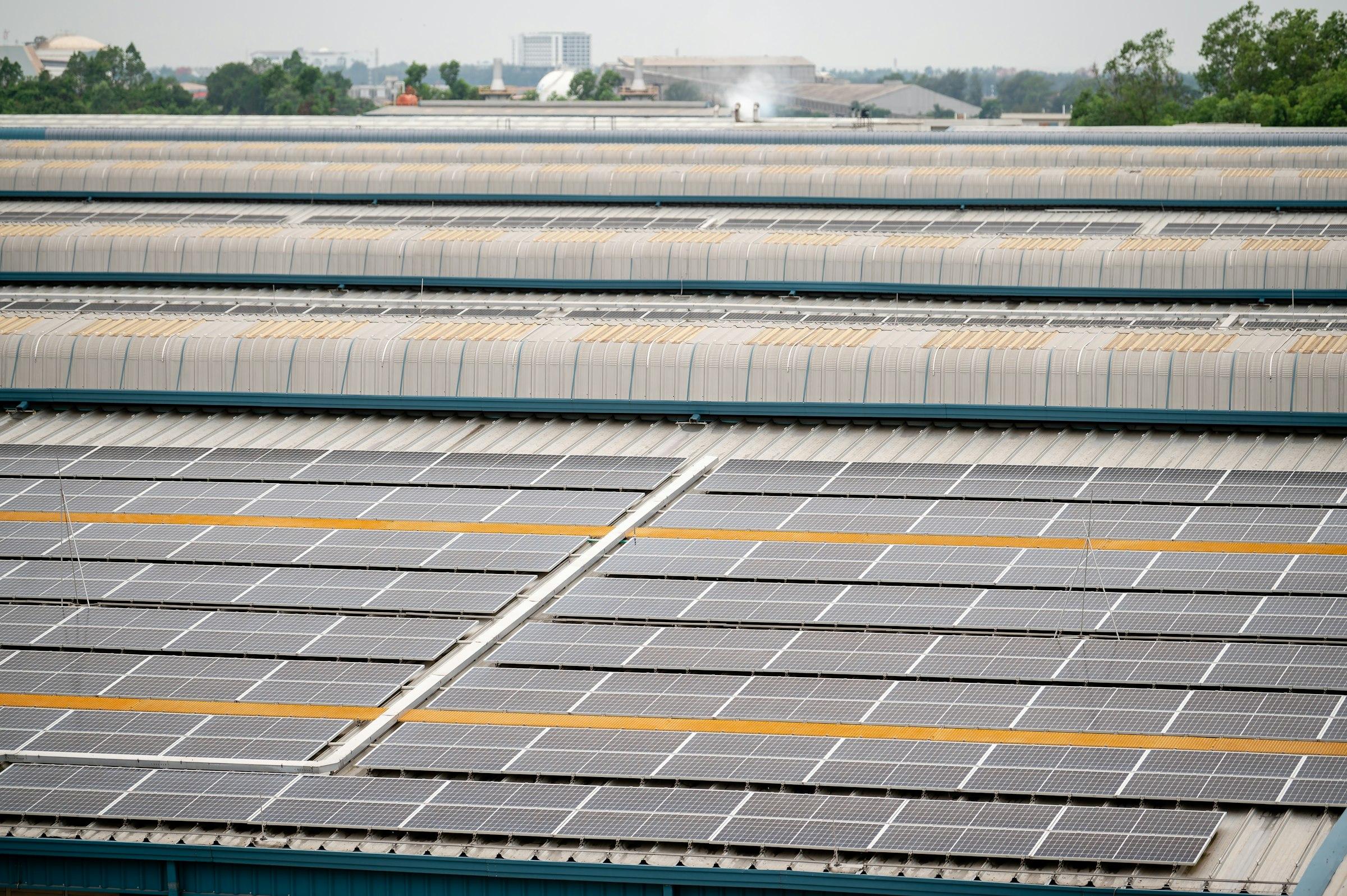 Rows of solar panels covering the roof of a large industrial building